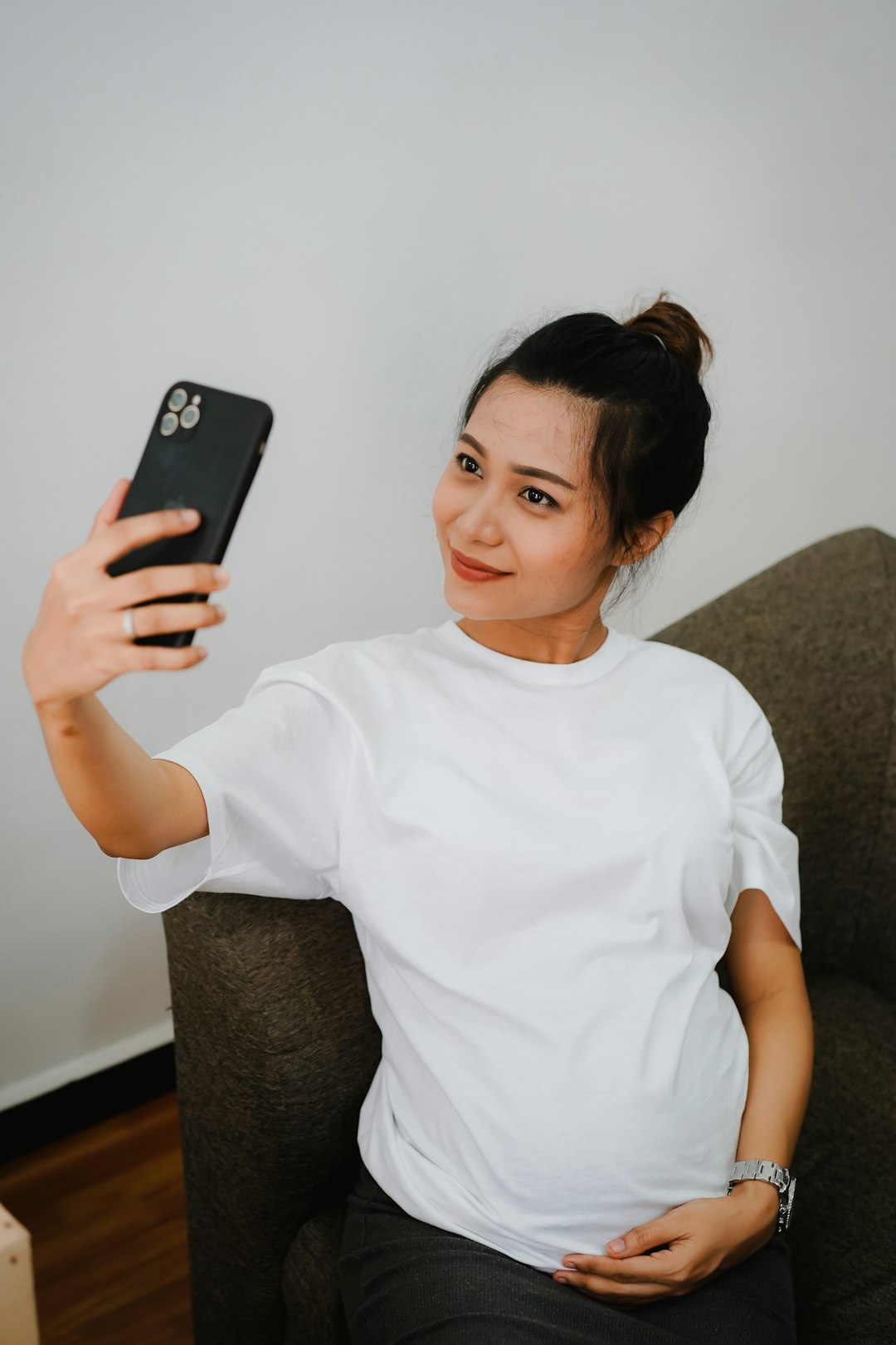 woman in white crew neck t-shirt holding black iphone 7 plus